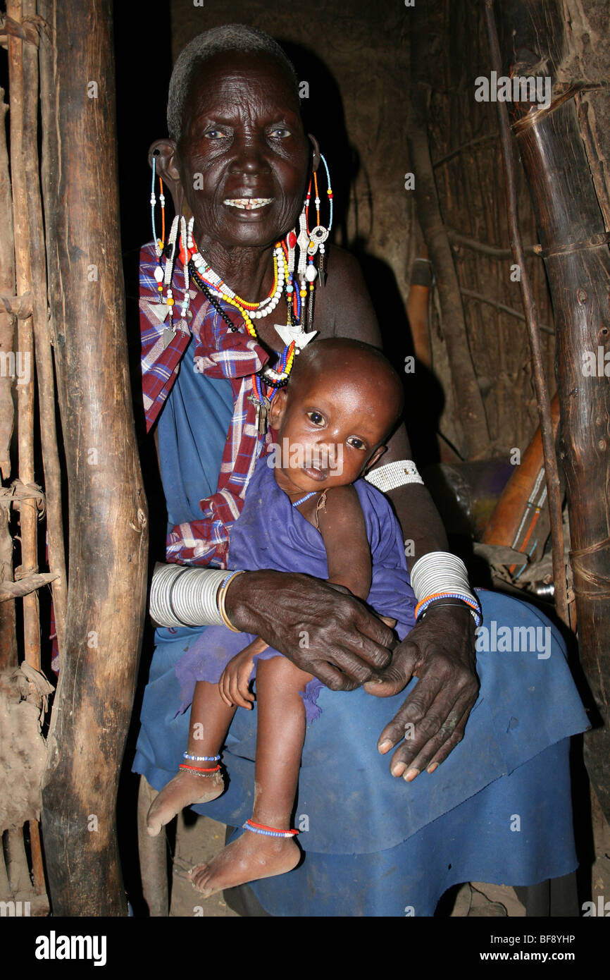 Personnes âgées Femme Masai Avec petit-enfant dans sa maison à Engaruka Village, vallée du Rift, en Tanzanie Banque D'Images