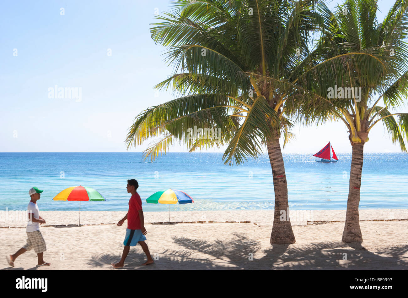 Deux hommes à marcher le long du chemin ; la plage de Boracay, Philippines Visayas. Banque D'Images