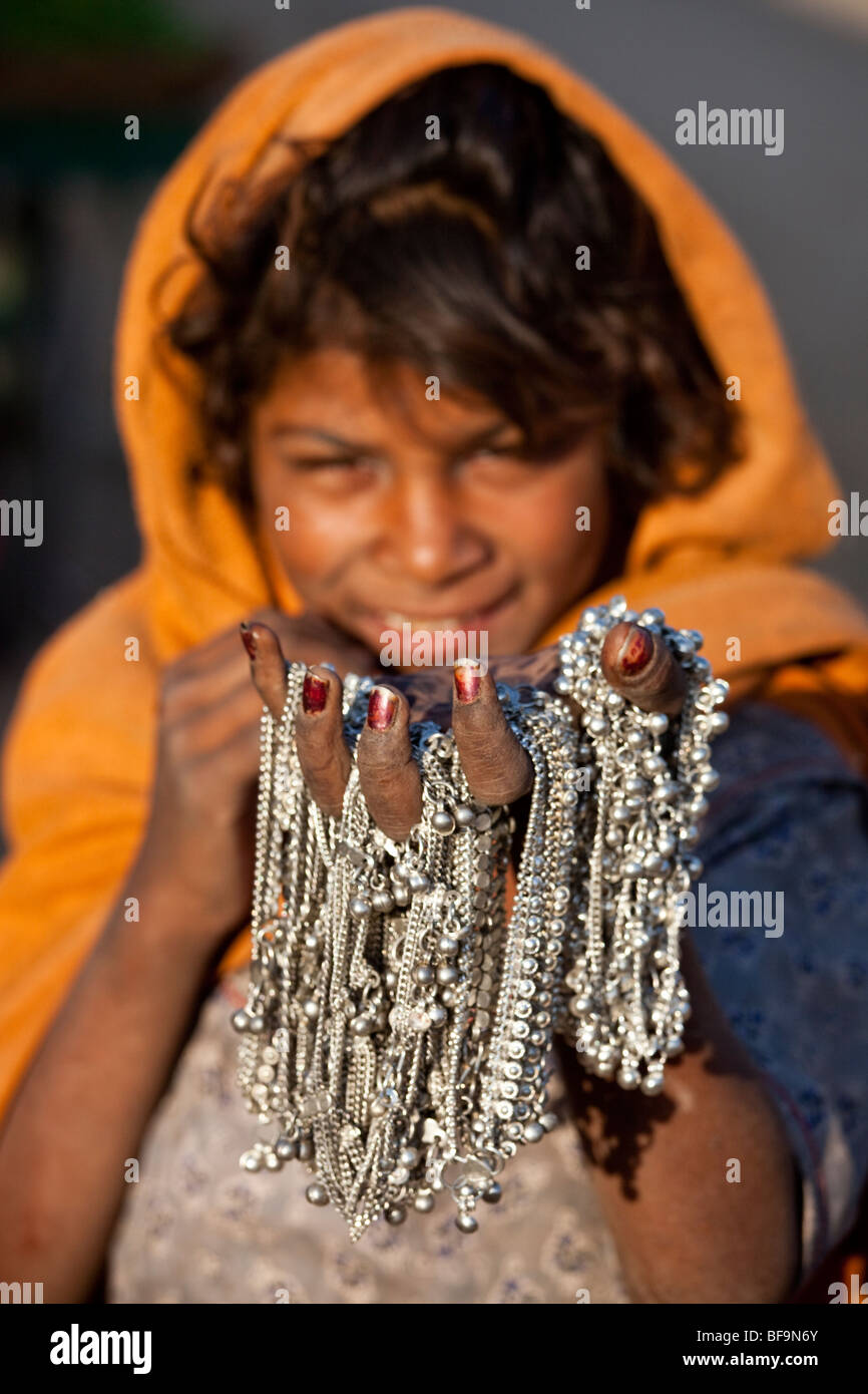 Jeune fille vendant des bracelets de cheville à la Camel Fair de Pushkar dans le Rajasthan en Inde Banque D'Images