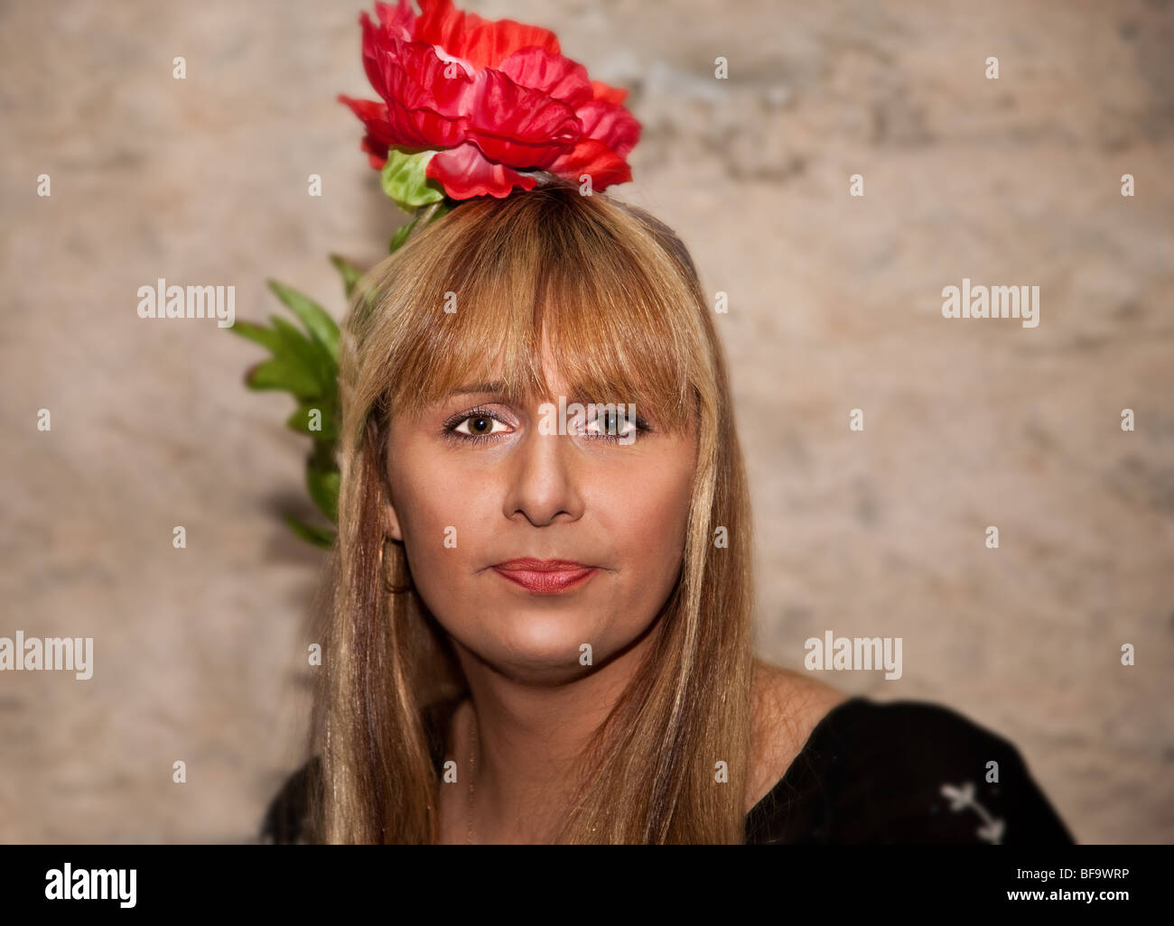 Portrait de fille avec fleur artificielle rouge Banque D'Images