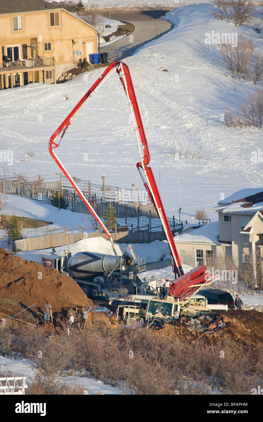 Les travailleurs de la construction des pieds de coulée avec une pompe à béton et grand boom dans un quartier chic près de Salt Lake City Banque D'Images