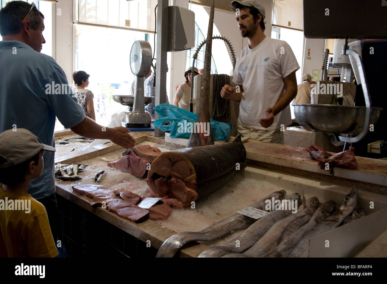 Homme et enfant d'acheter du poisson frais à l'intérieur du marché aux poissons, Lagos, Portugal Banque D'Images