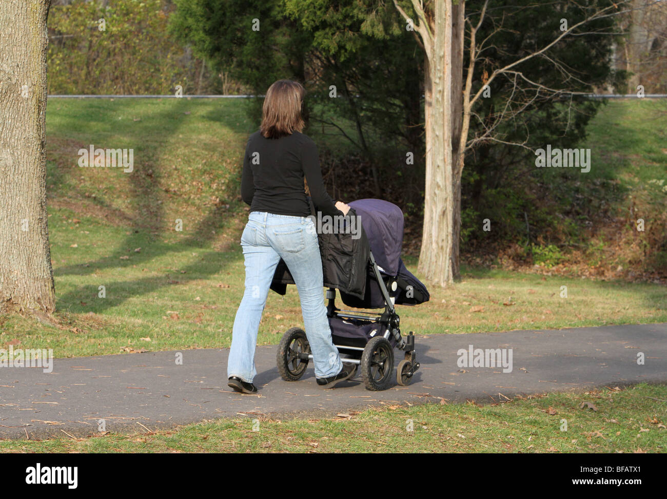 Une jeune mère promener son bébé dans le parc. Banque D'Images