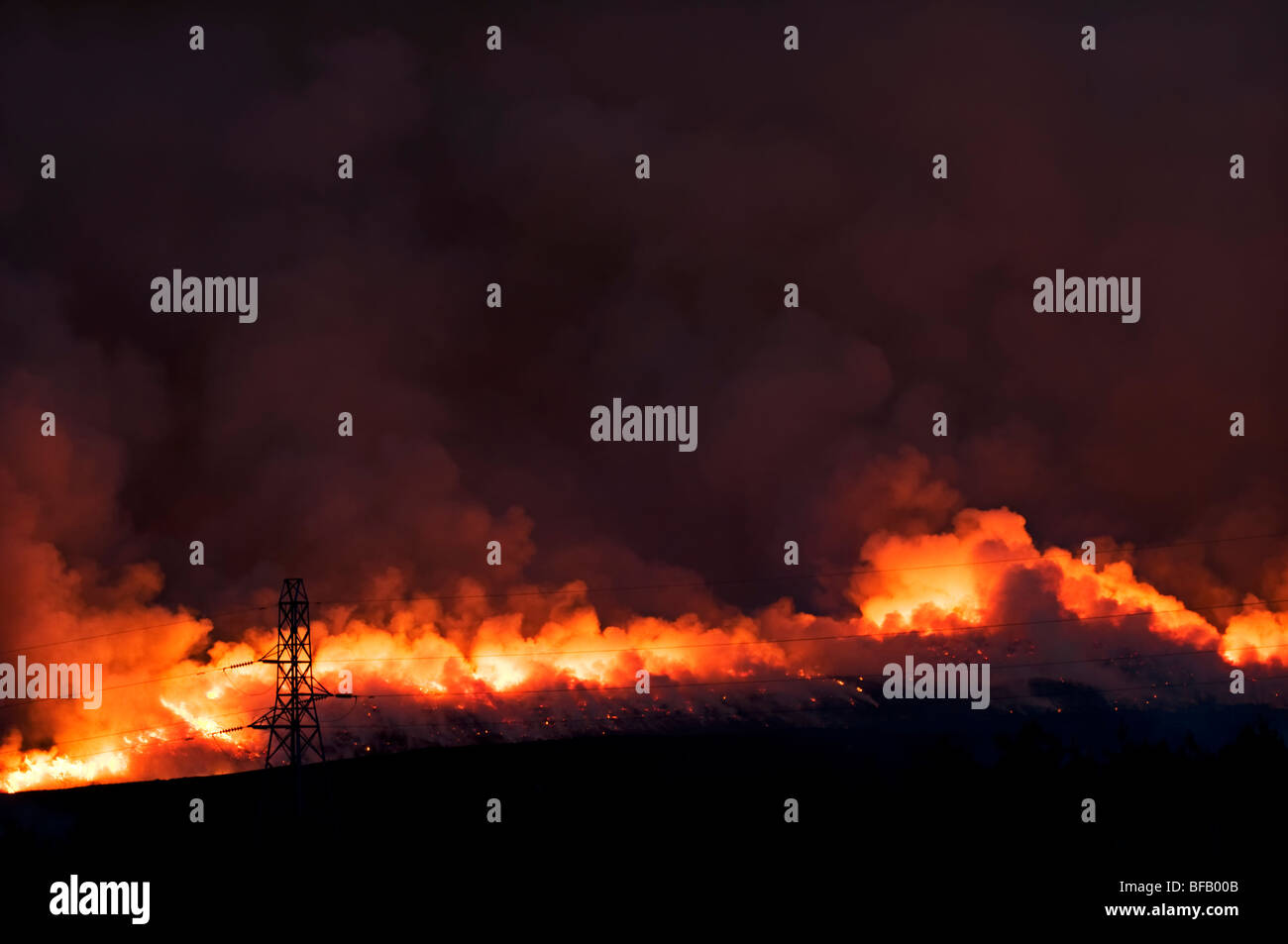 Un feu de broussailles intense sur les collines près de l'A836 entre Lairg et Bonar Bridge en Ecosse prises au crépuscule Banque D'Images