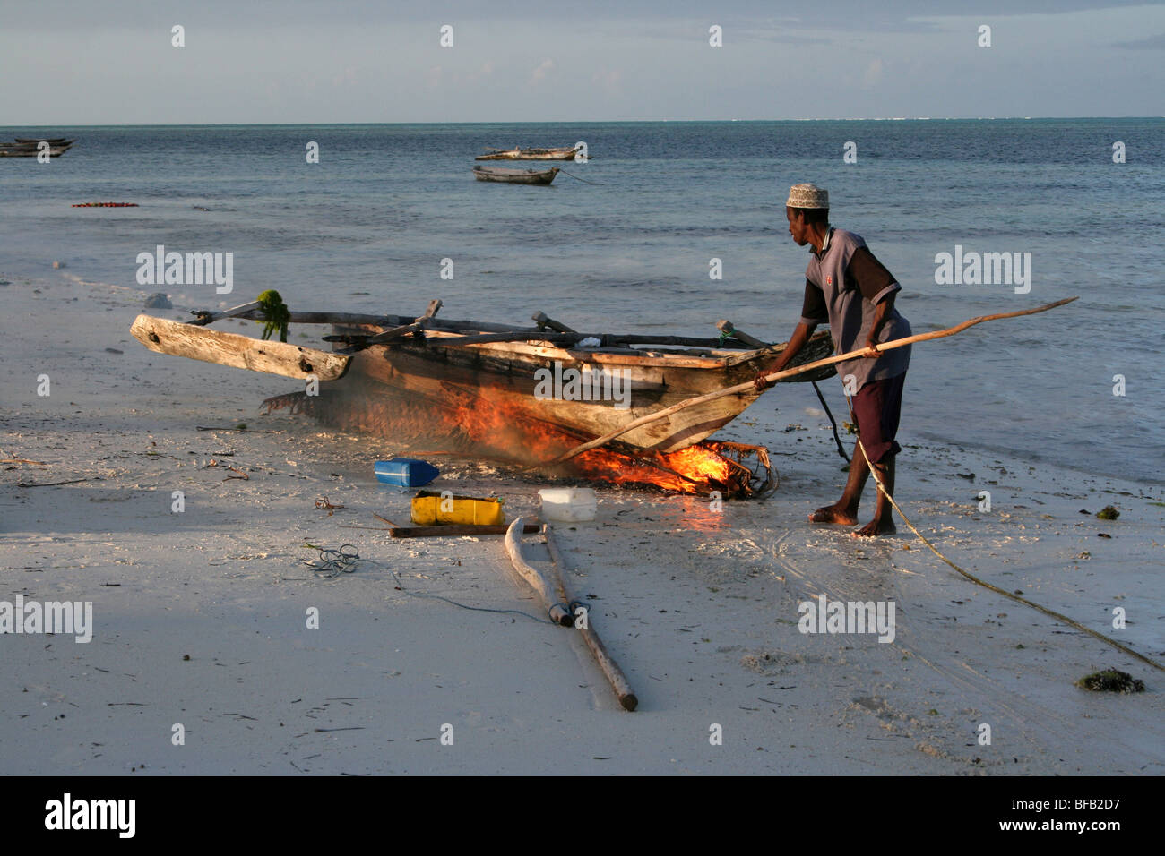 Brûler les algues marines la coque d'un bateau sur la plage de Jambiani, Zanzibar Banque D'Images