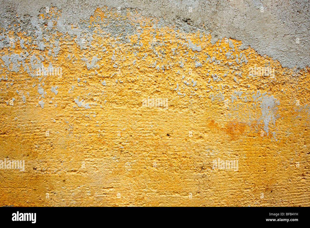 Mur de platère peint en jaune orange avec surface de peinture vieillissante, texture rustique Banque D'Images