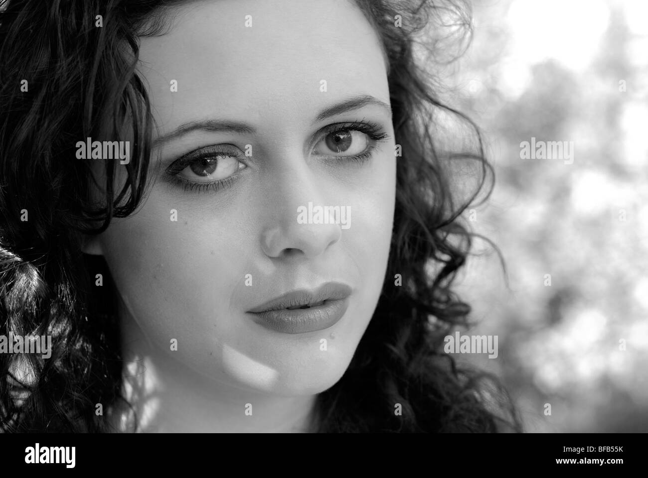 Portrait de la belle jeune femme brune à l'extérieur dans la lumière pommelé. Banque D'Images