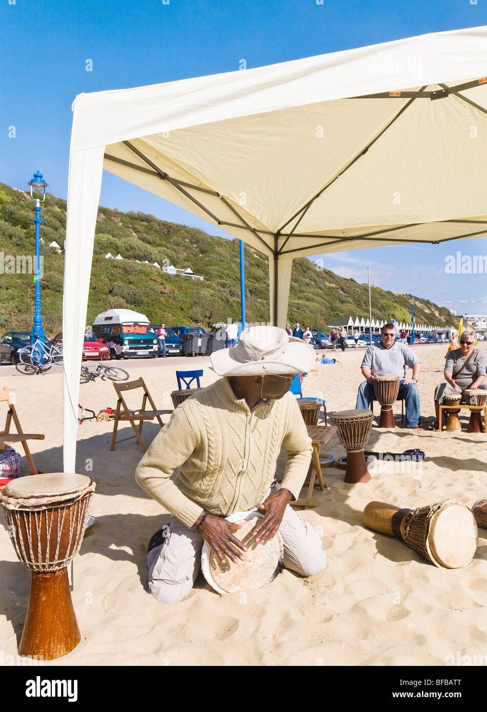 Un atelier de percussion. Un instructeur donne une leçon de tambour pour les vacanciers sur la plage, Boscombe Bournemouth, Dorset. UK. Banque D'Images
