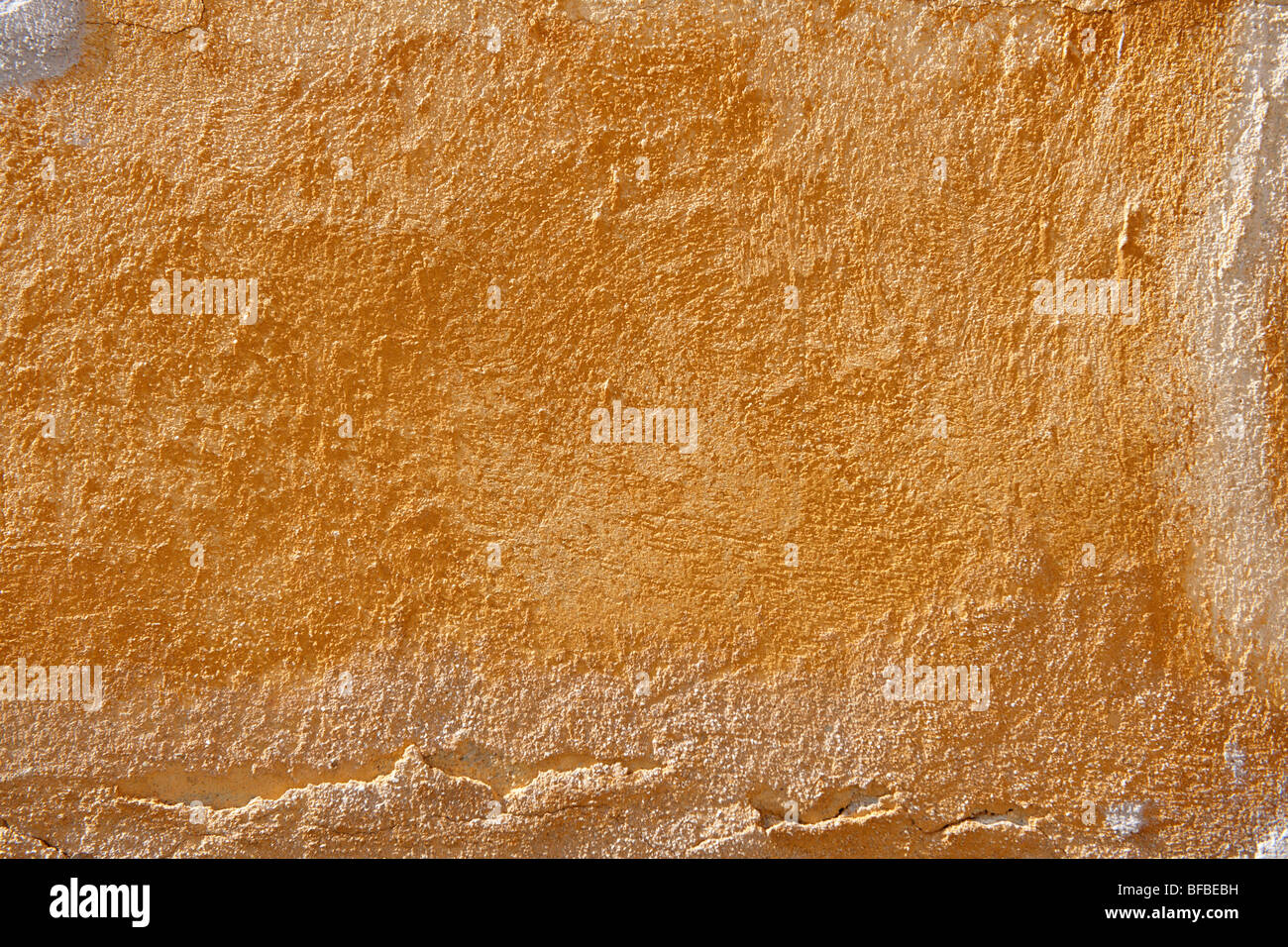Mur de platère peint en jaune orange avec surface de peinture vieillissante, texture rustique Banque D'Images