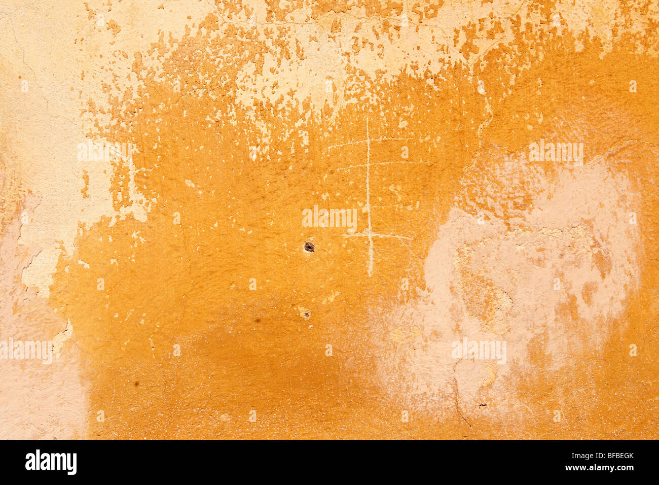 Mur de platère peint en jaune orange avec surface de peinture vieillissante, texture rustique Banque D'Images