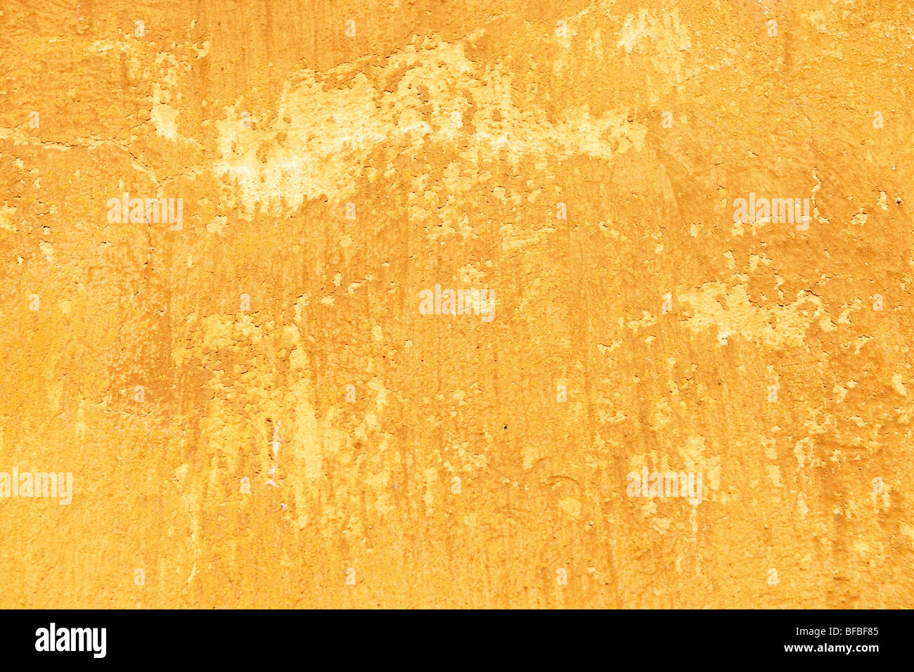 Mur de platère peint en jaune orange avec surface de peinture vieillissante, texture rustique Banque D'Images