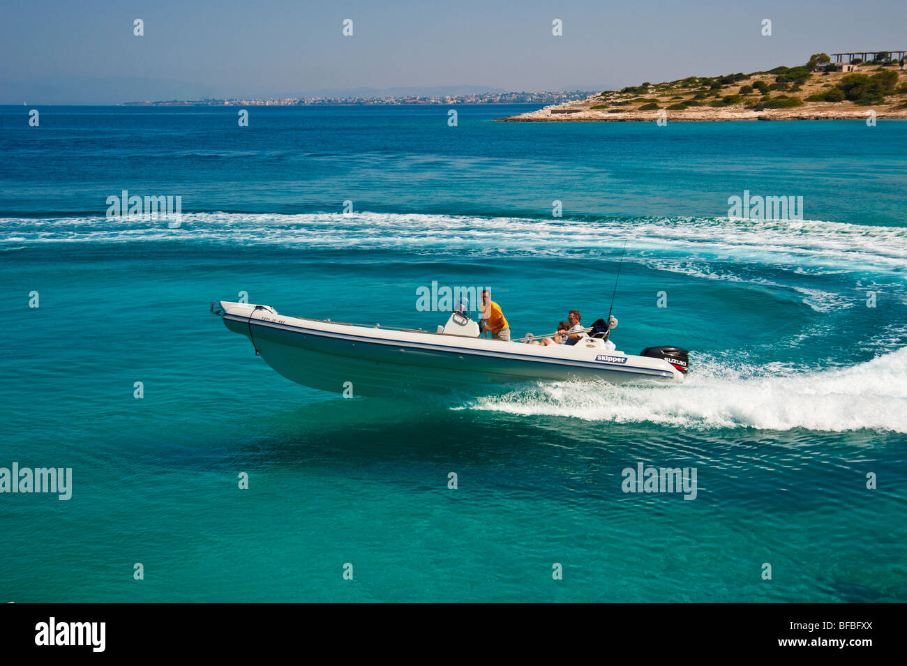 Bateau gonflable dans l'eau bleu en courbe, Saroic Golf, Grèce Banque D'Images