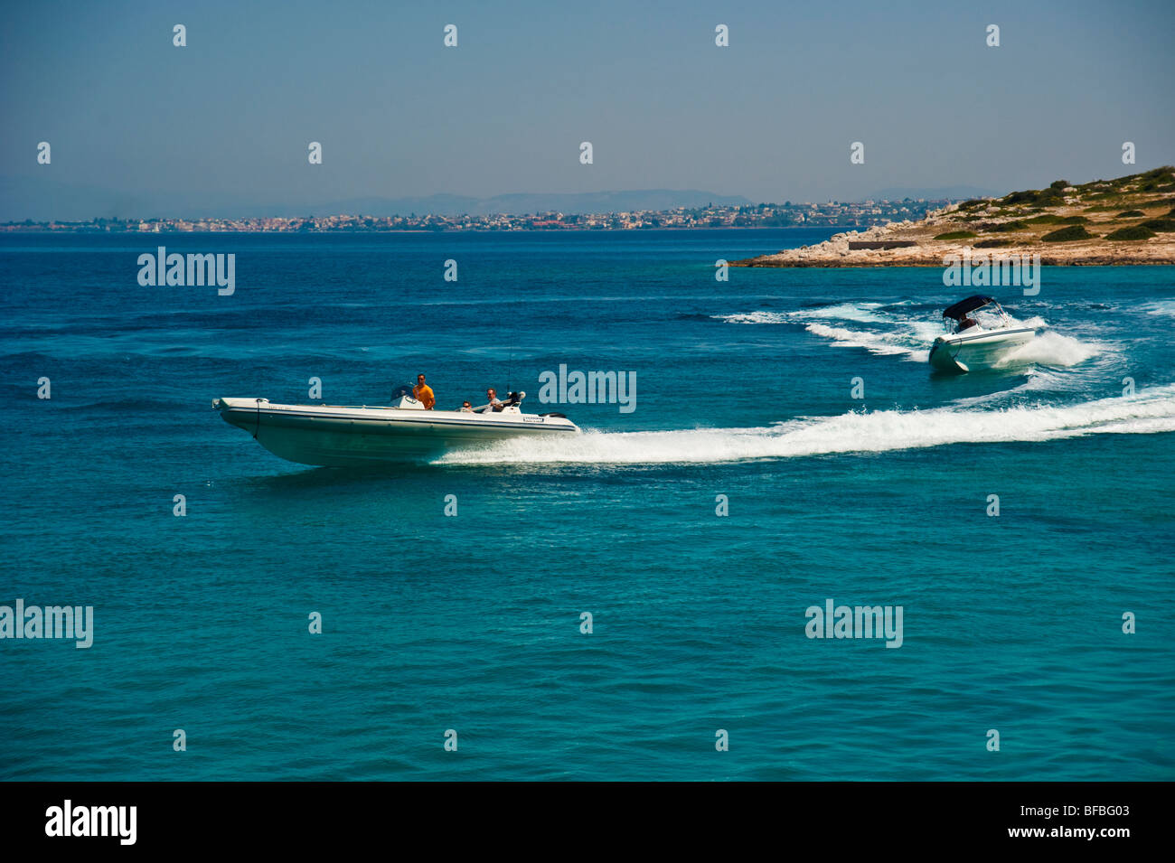 Les bateaux gonflables courbant en bleu de l'eau, Saroic Golf, Grèce Banque D'Images