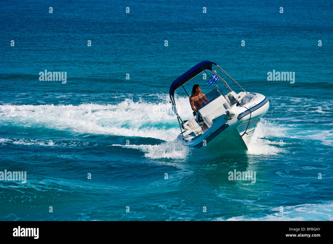 Bateau gonflable blanc courbant avec grande vitesse dans l'eau bleue, Saroic Golf, Grèce Banque D'Images