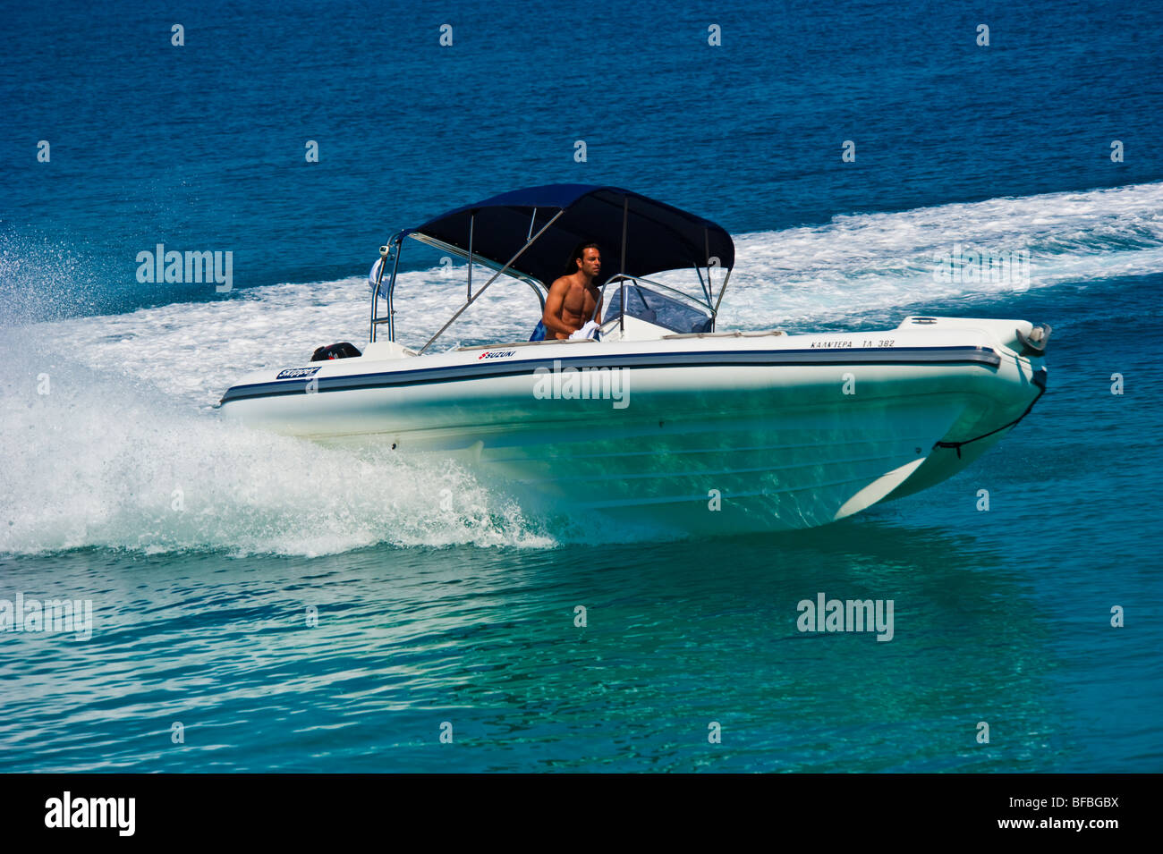 Bateau gonflable blanc courbant avec grande vitesse dans l'eau bleue, Saroic Golf, Grèce Banque D'Images