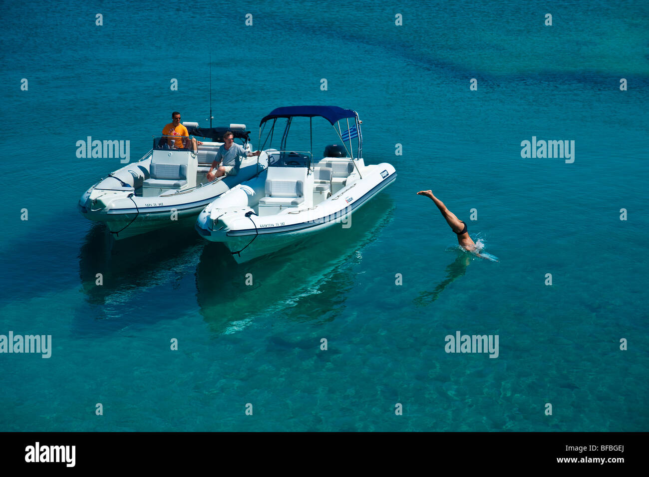 Man jumping de bateau gonflable dans l'eau bleue, Saroic Golf, Grèce Banque D'Images