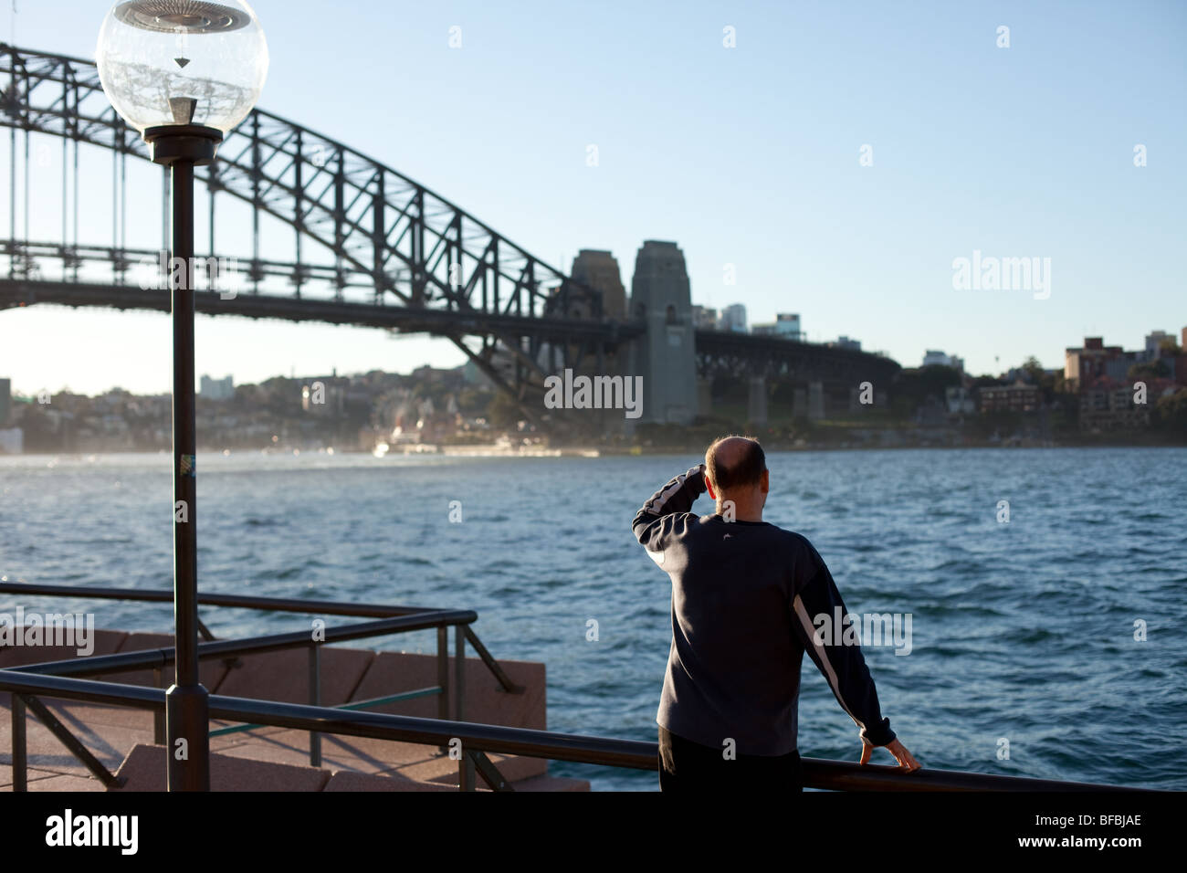 Un homme donne sur le port de Sydney de l'Opéra. Banque D'Images