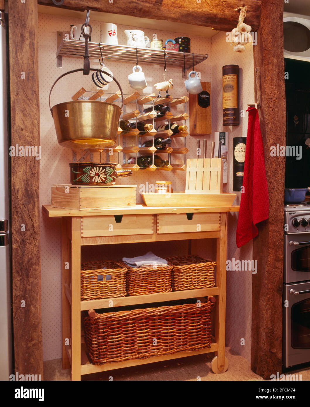 Close-up de coin de cuisine traditionnelle avec vin et pan en laiton  au-dessus du rack de stockage unité étagère en bois avec des paniers en  osier avec Photo Stock - Alamy