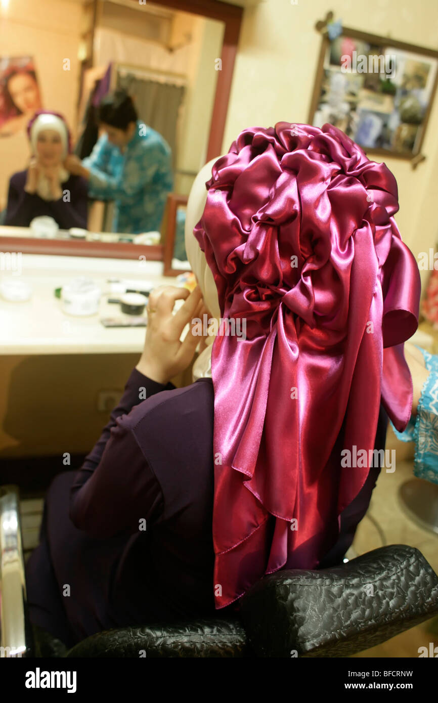 Femme d'avoir un foulard couvrant monté à un salon de coiffure pour un mariage, Istanbul, Turquie Banque D'Images