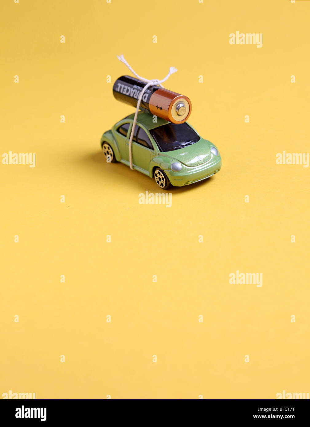 Petite voiture avec batterie attaché en haut d'une corde pour illustrer une pile de rechange et l'utilisation de l'énergie verte. Banque D'Images
