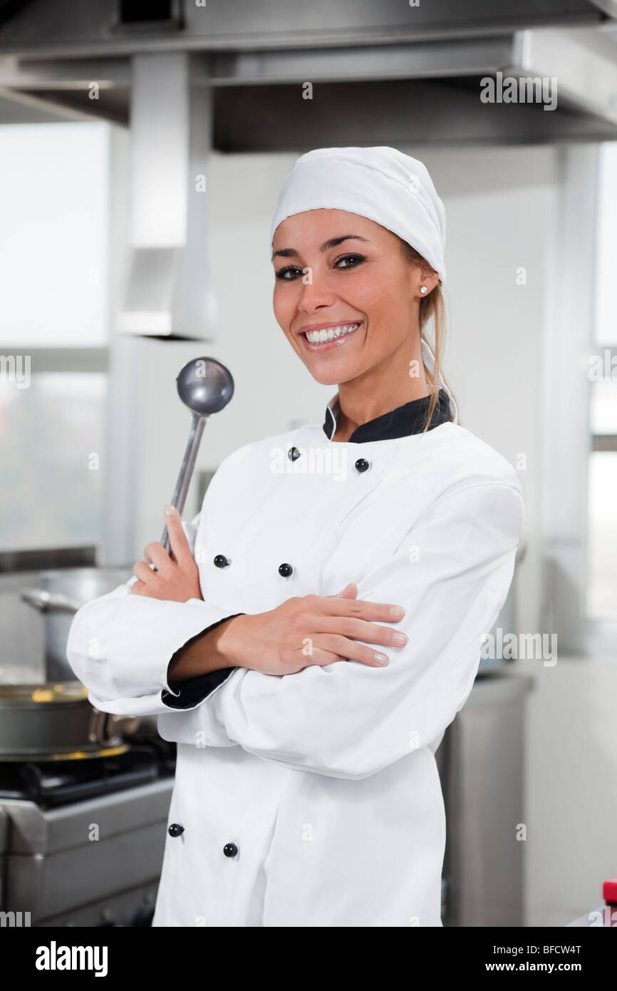 Portrait of female chef looking at camera in kitchen Banque D'Images