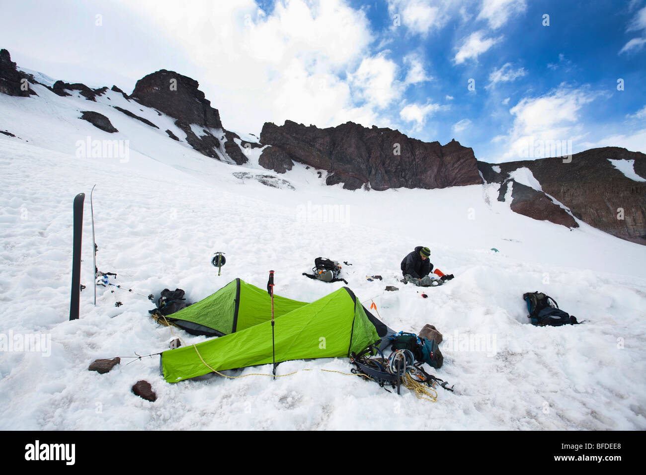 Deux sacs de bivouac et skis indiquent un camping au milieu de névé.eld. Banque D'Images