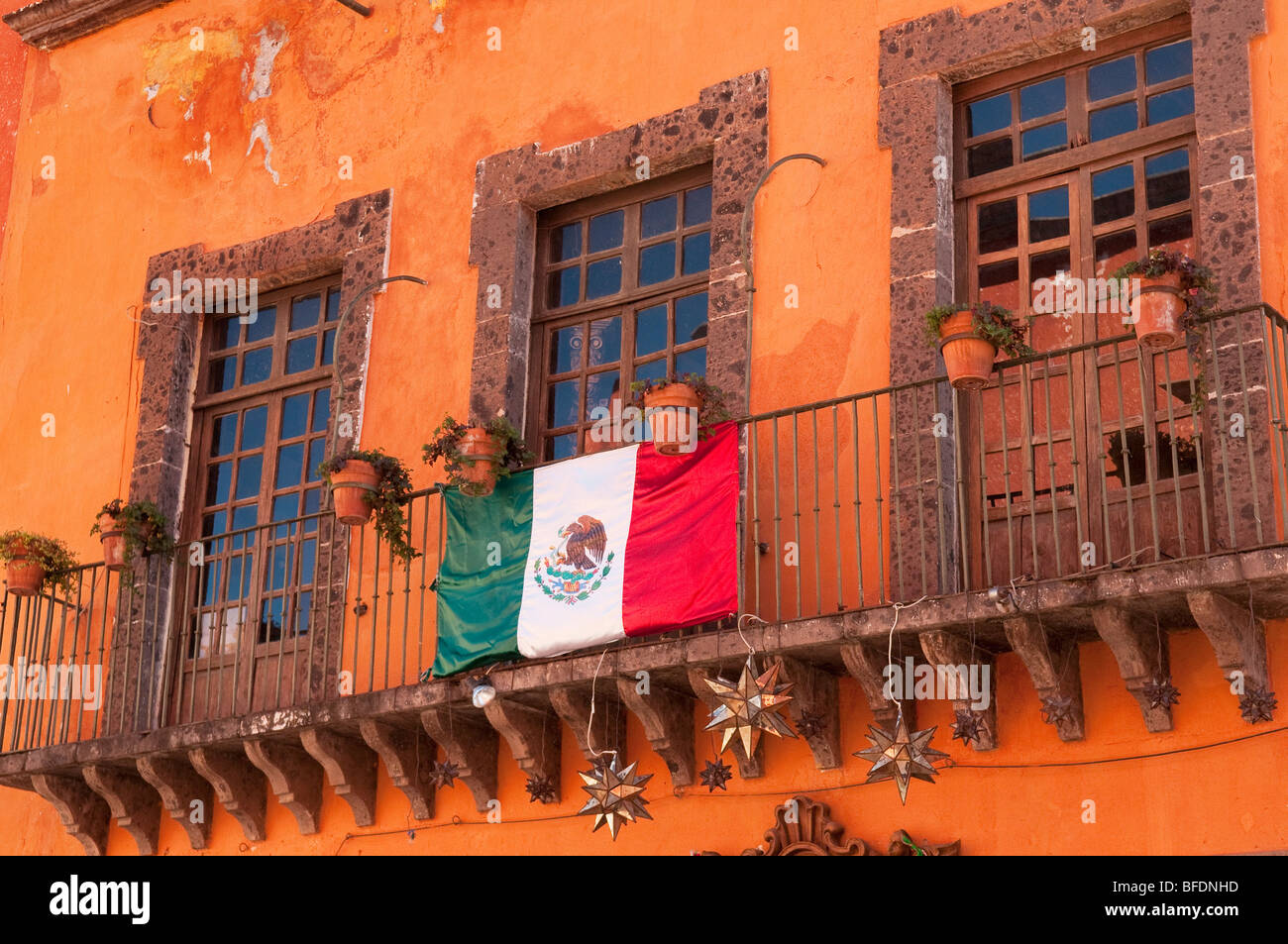Fenêtres et drapeau mexicain sur balcon de l'appartement à San Miguel de Allende, Guanajuato, Mexique. Banque D'Images