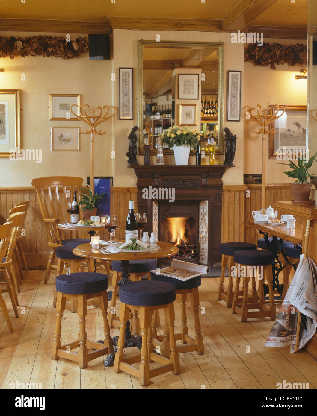 Tables et chaises en pin country restaurant traditionnel avec cheminée à feu lumineux Banque D'Images