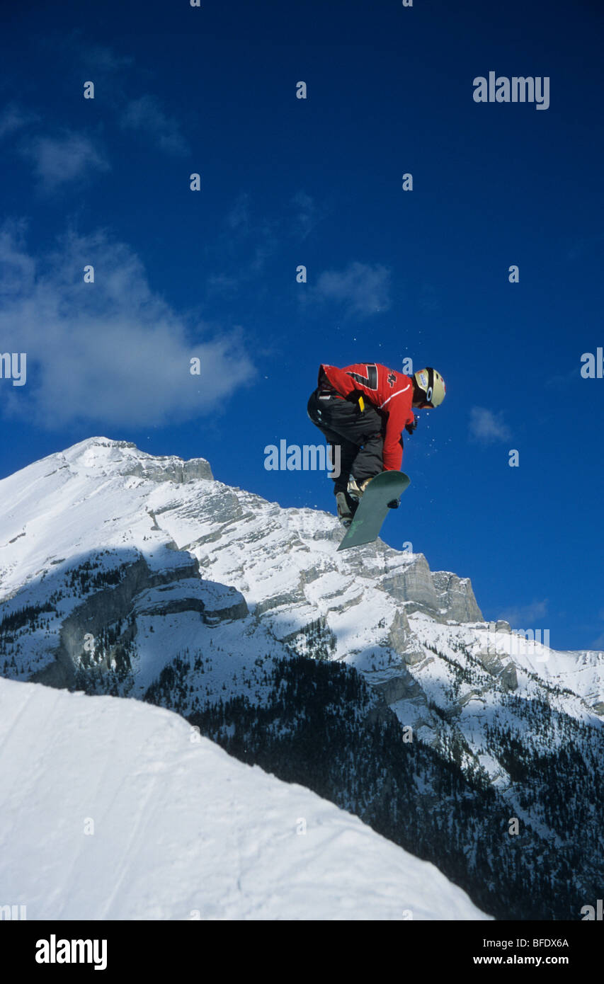 Un snowboarder attrapant un peu d'air du mont Norquay resort, Banff National Park, Alberta, Canada Banque D'Images