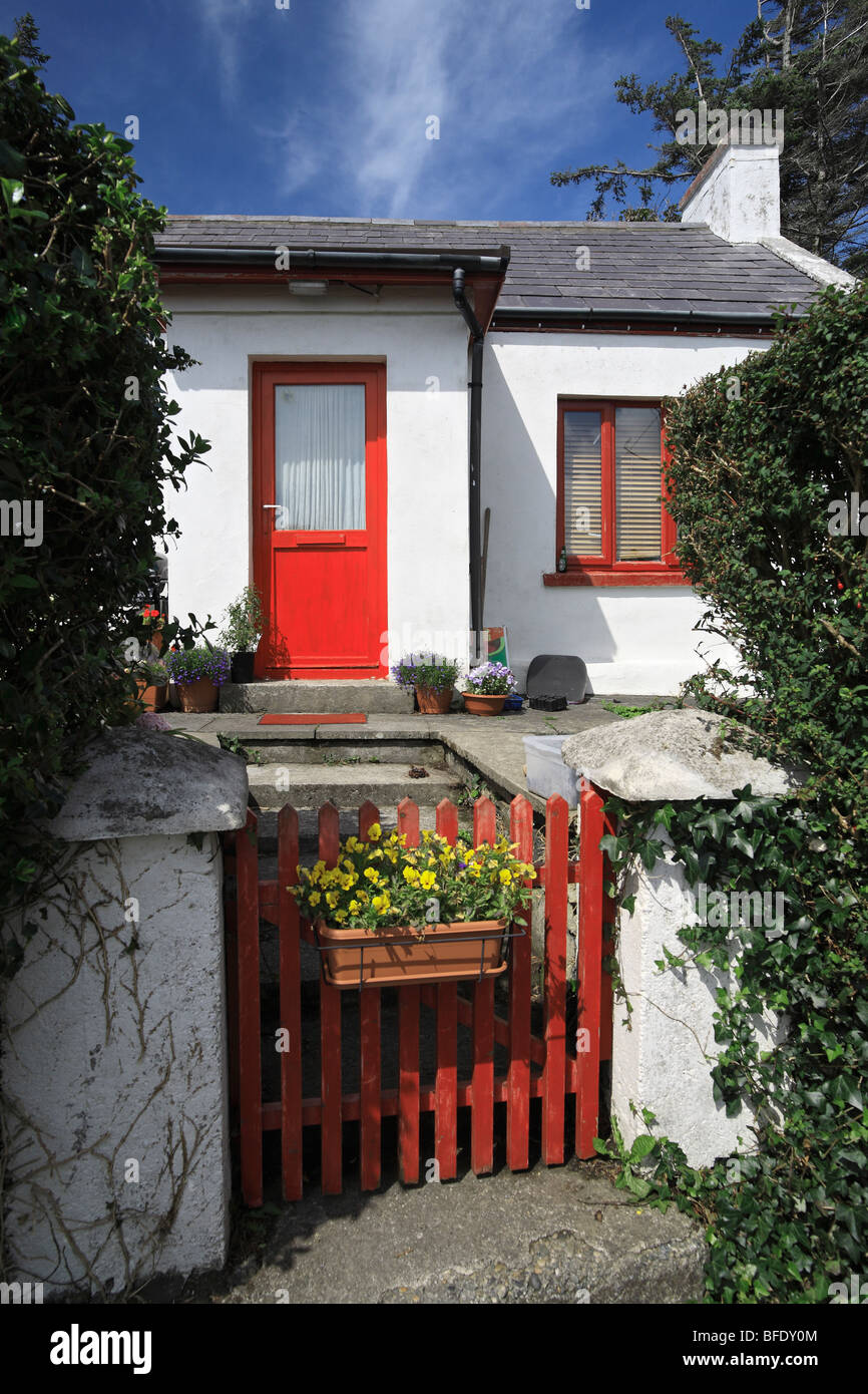 Cottage traditionnel avec la porte rouge et l'alto à l'entrée de la sky road près de Clifden dans le Connemara, Irlande Banque D'Images