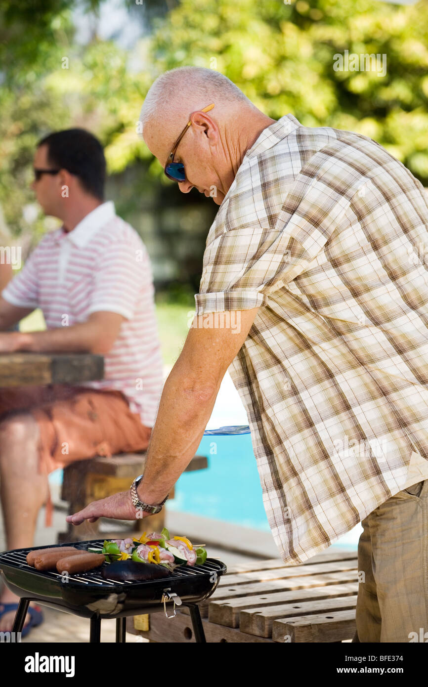 Vieil homme à un barbecue familial, jour de l'indépendance. Banque D'Images