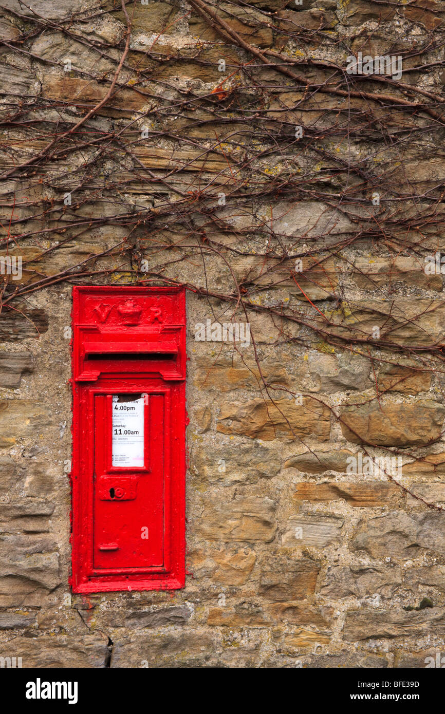 Post box sur mur de pierre d'une maison de Thwaite, Swaledale, Yorkshire Dales England UK en attente de courrier de Noël. Banque D'Images