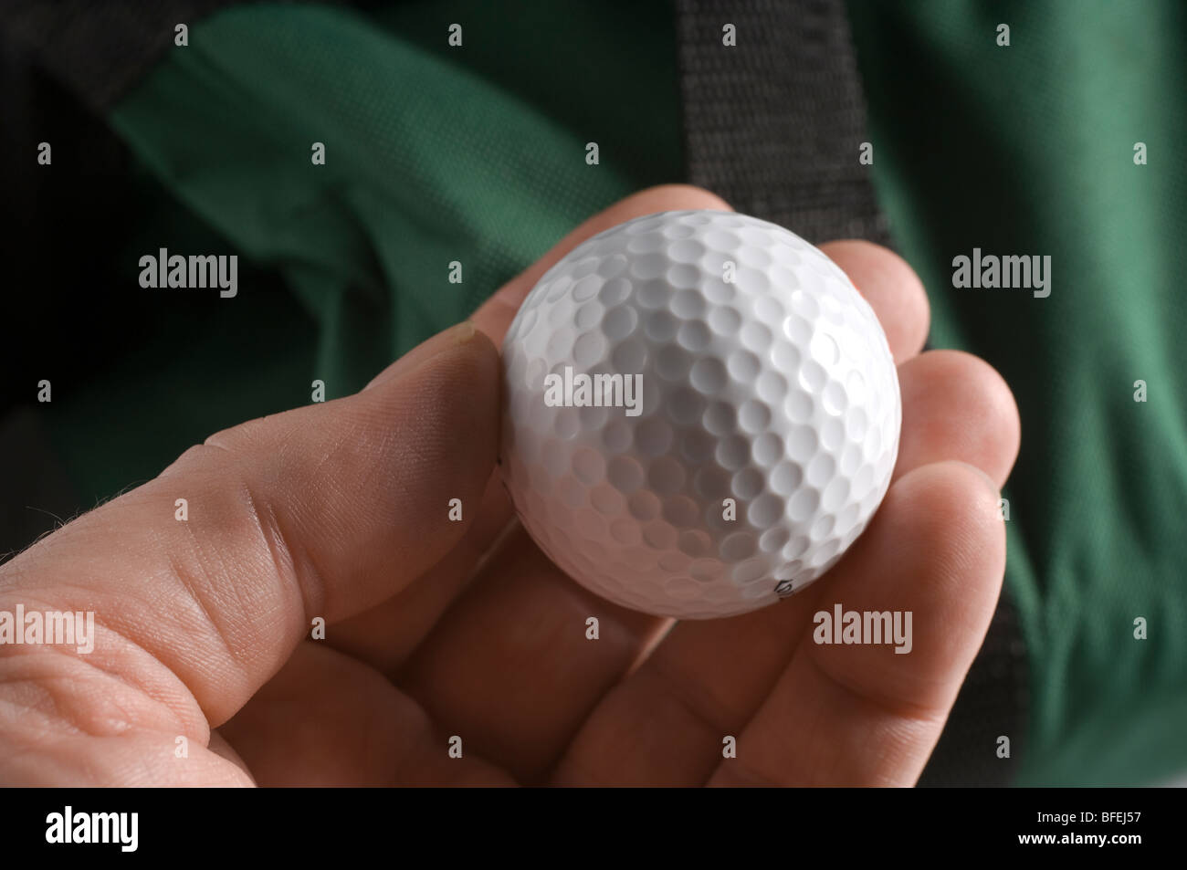 La main d'un homme tenant une balle de golf. Banque D'Images