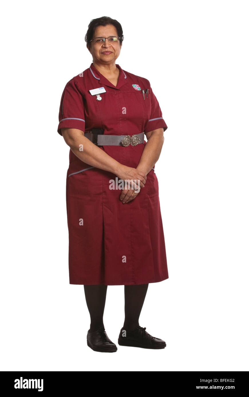 Infirmière asiatique se dresse contre un arrière-plan blanc dentelle UK Banque D'Images