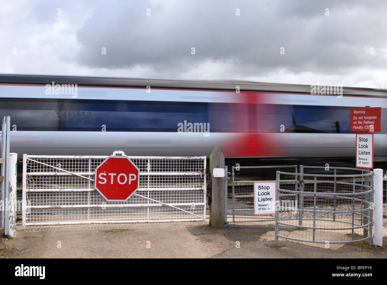 Passage du train au passage à niveau de gating habités, Worcestershire, Angleterre, Royaume-Uni Banque D'Images