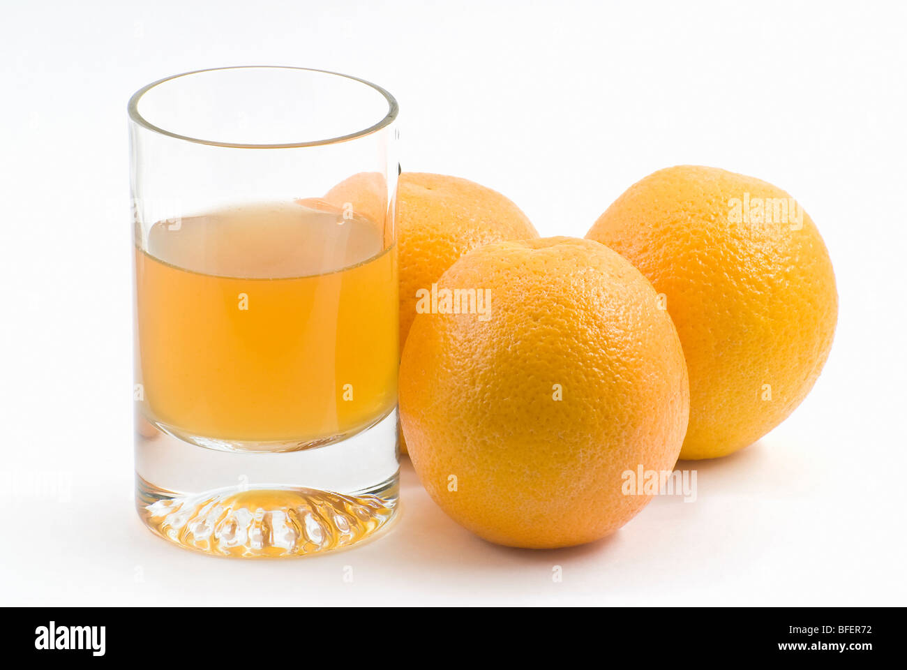 Le verre de jus et les trois oranges Banque D'Images