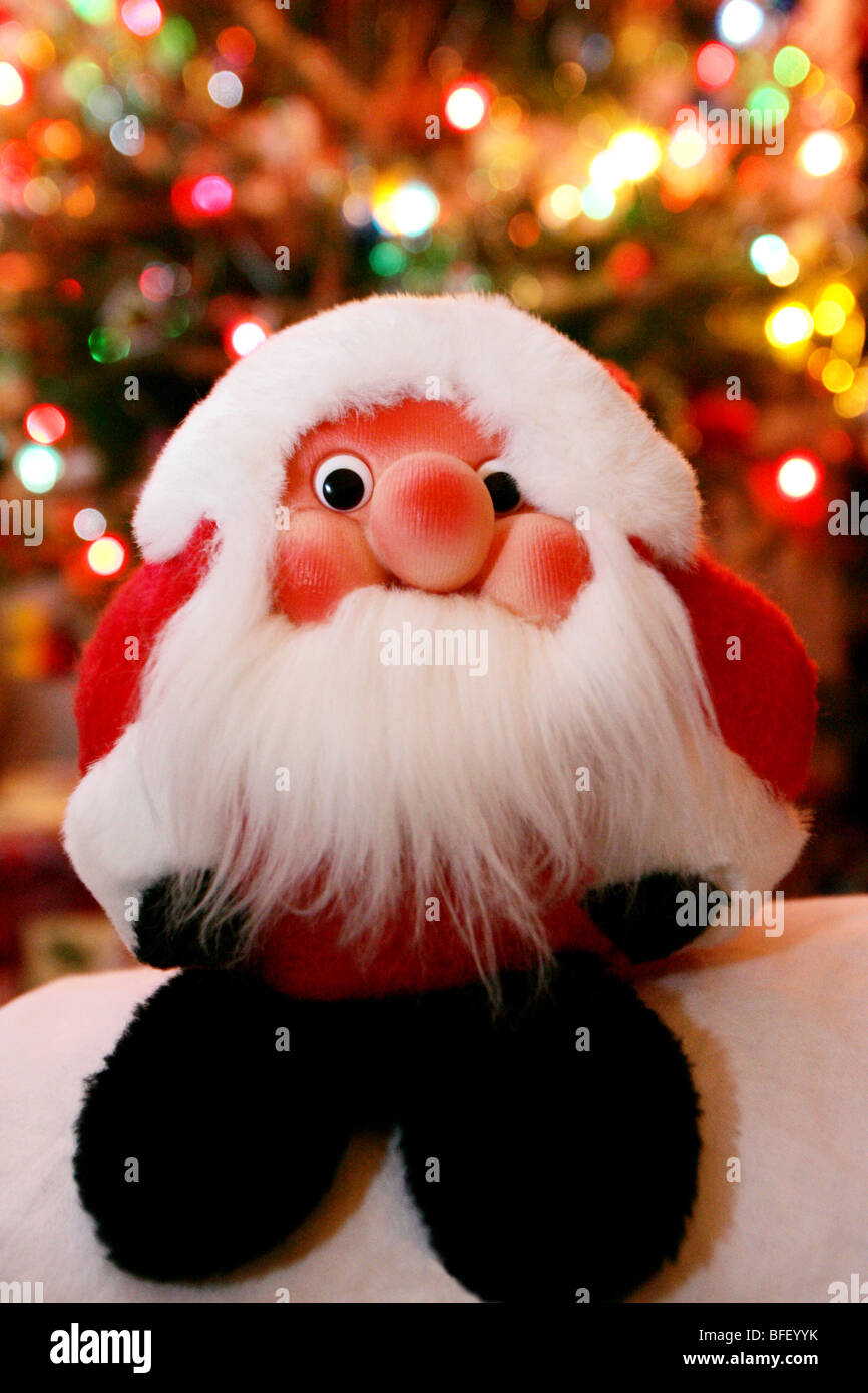 Peluche père Noël avec arbre de Noël en arrière-plan flou. Banque D'Images