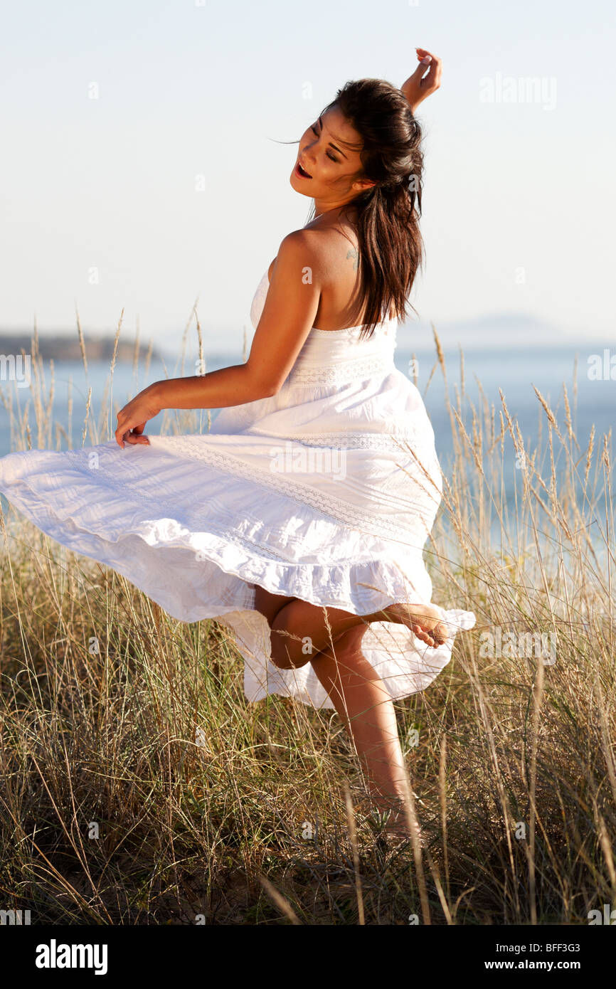 Girl dancing en herbe des dunes de sable, heureux, courir, danser Banque D'Images