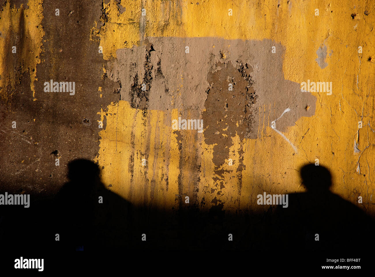 Mur jaune avec des silhouettes de deux personnes Banque D'Images