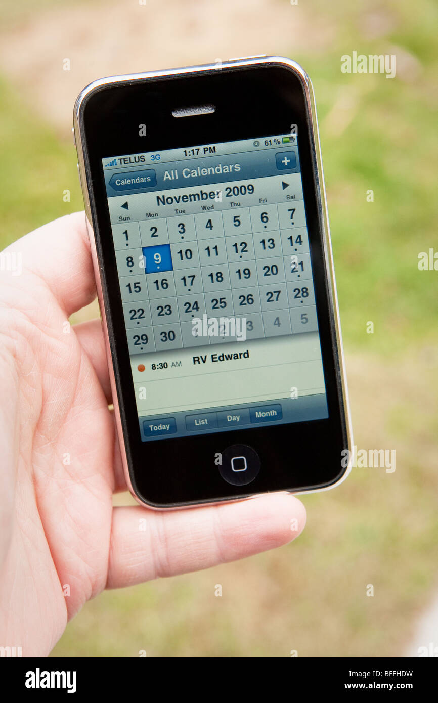 Un homme utilisez l'application de calendrier sur un iPhone d'Apple Banque D'Images
