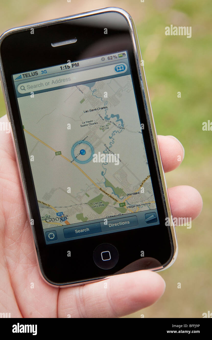 Un homme utiliser la carte application sur un iPhone d'Apple. Banque D'Images