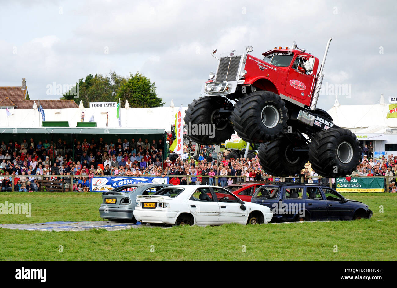 Les lecteurs de Monster truck sur une ligne de voitures anciennes Banque D'Images