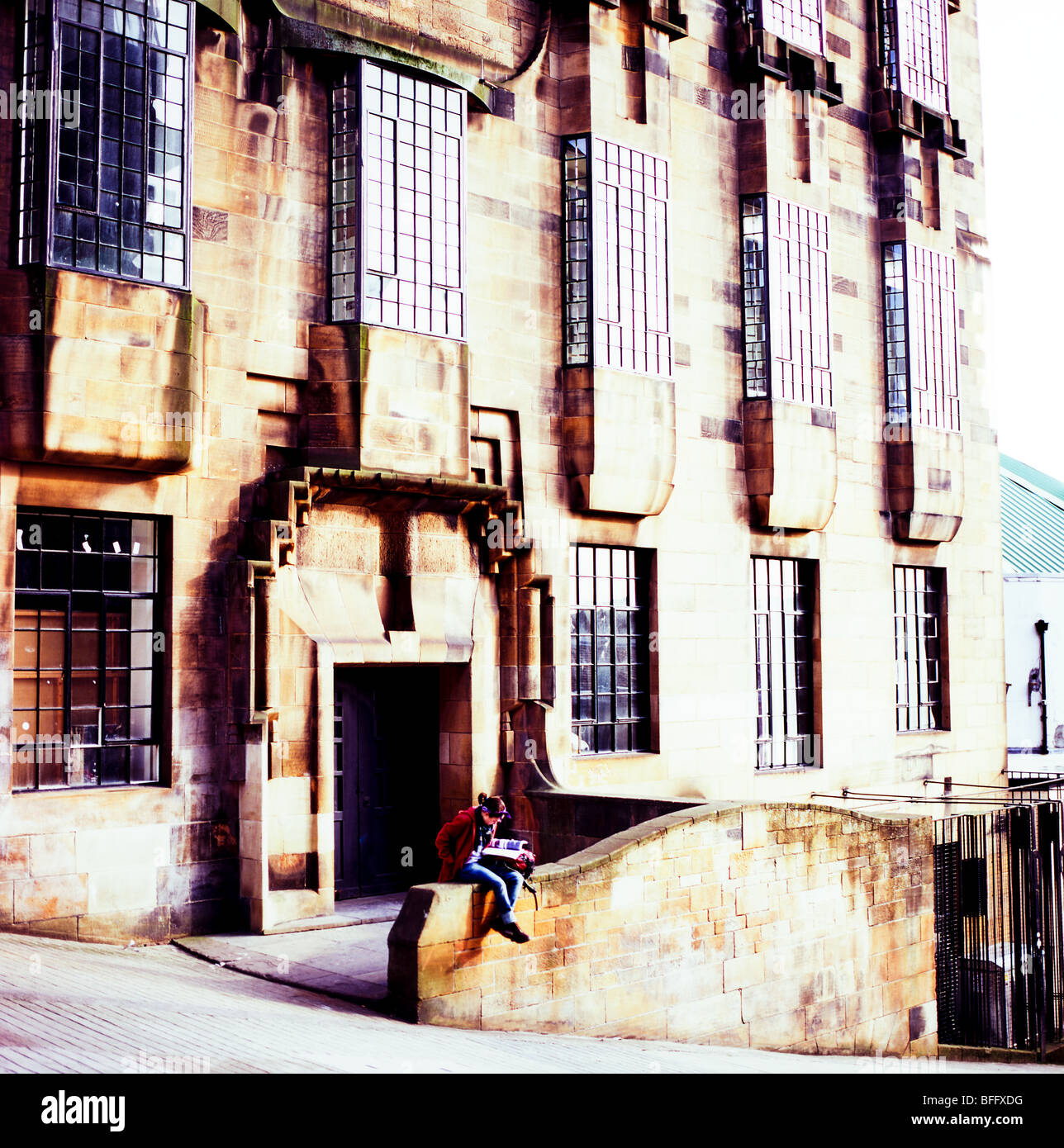 Une jeune fille lisant un livre à l'extérieur de la Glasgow School of Art building par Charles MacIntosh Renee Glasgow UK KATHY DEWITT Banque D'Images