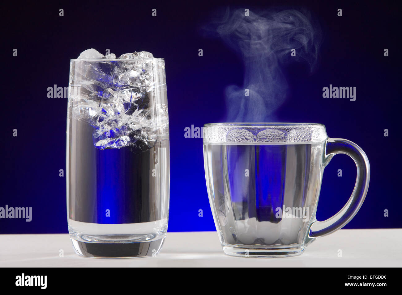 L'eau de vapeur de la glace. Un verre d'eau glacée et une tasse de thé de l'eau vapeur chaude. Banque D'Images