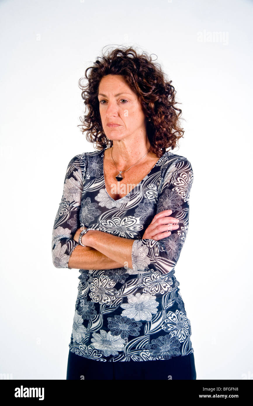 Debout, les bras croisés sur sa poitrine indique une humeur défensive dans cette femme. Banque D'Images
