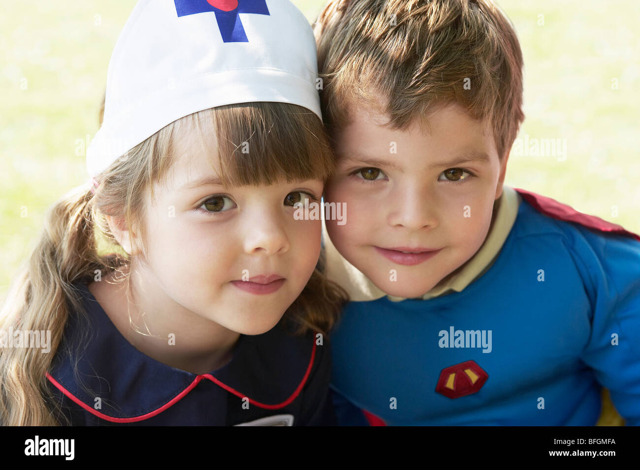 Fille et garçon habillé en super-héros et infirmière en park, portrait Banque D'Images