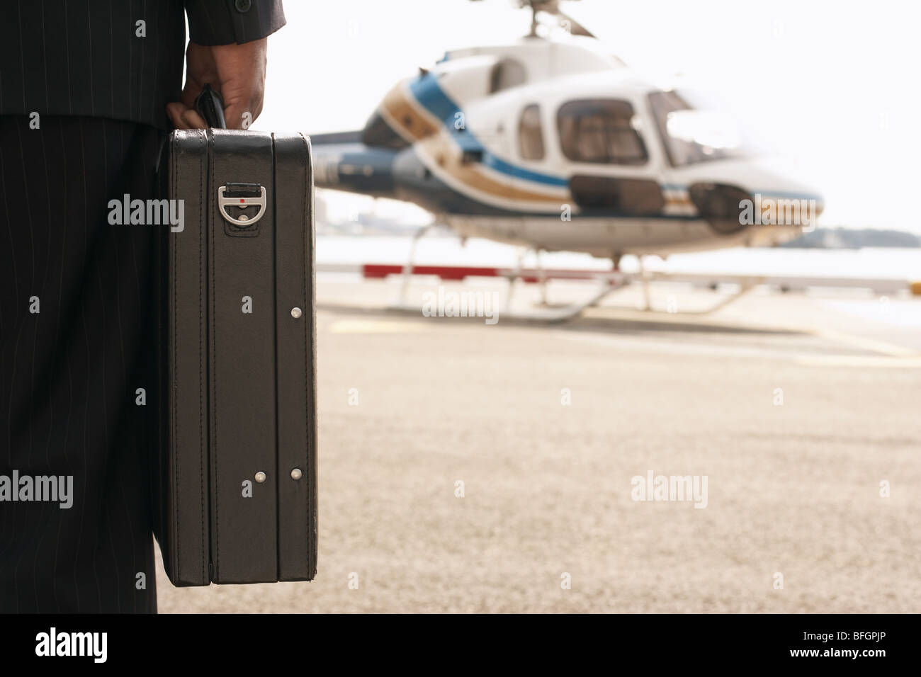 Businessman with briefcase, sur l'atterrissage d'hélicoptère Banque D'Images