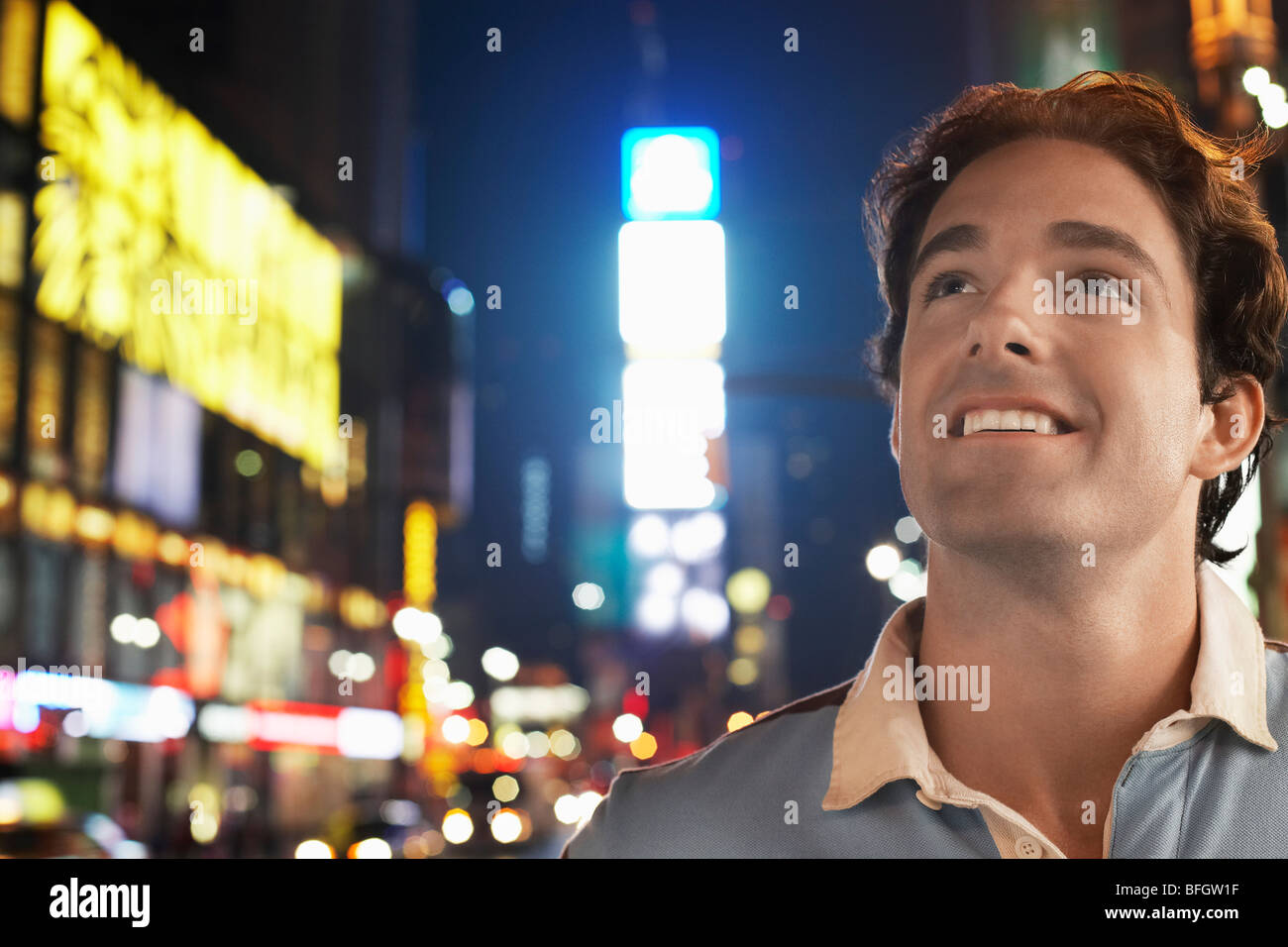 Young man standing in Times Square New York la nuit Banque D'Images