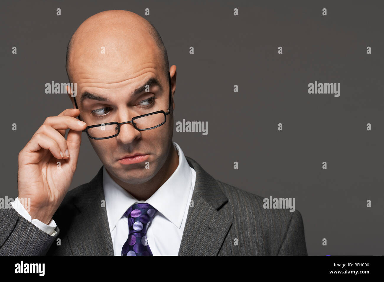 Balding businessman part sur des verres, making a face Banque D'Images