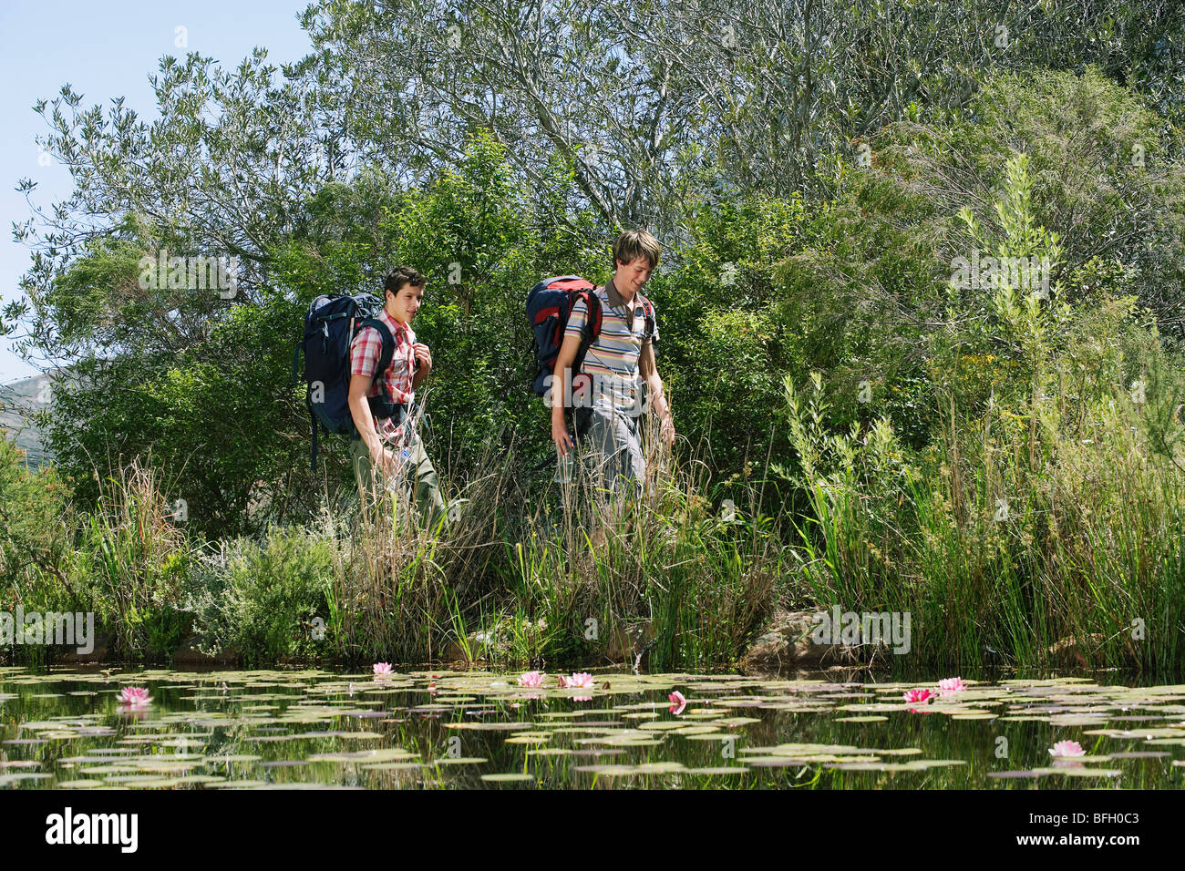 Deux adolescents (16-17 ans) par le lac à pied avec des sacs à dos Banque D'Images